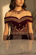 Close-up of sweetheart neckline gold trim and wide zardozi cummerbund belt on burgundy velvet gown